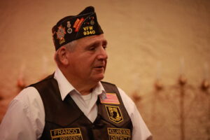 A man in uniform with a flag on his vest.