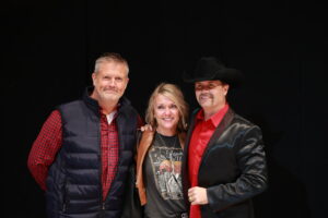 A woman and two men posing for the camera.