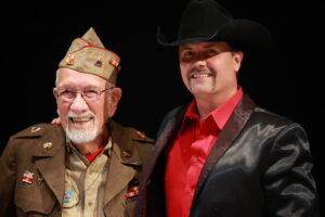 Two men in military uniforms and a cowboy hat.