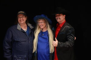 Three people posing for a picture in front of a black background.