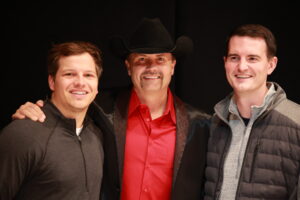 Three men standing next to each other in a room.