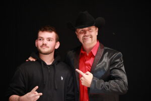 A man and a boy in black jackets posing for the camera.