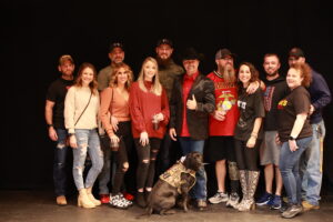A group of people and their dog posing for the camera.