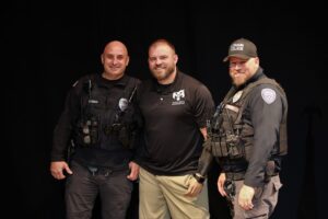 Three men in police uniforms posing for a picture.
