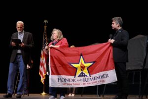 A woman holding an honor and remember flag