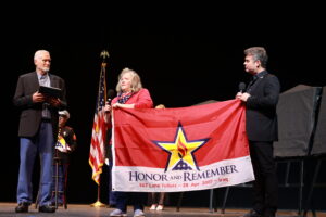 A woman holding an american flag on stage.