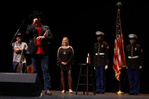 A man and woman on stage with an officer.