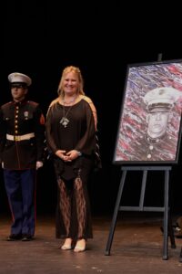 A woman standing next to an officer in front of a painting.