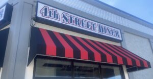 A restaurant with red and black striped awning