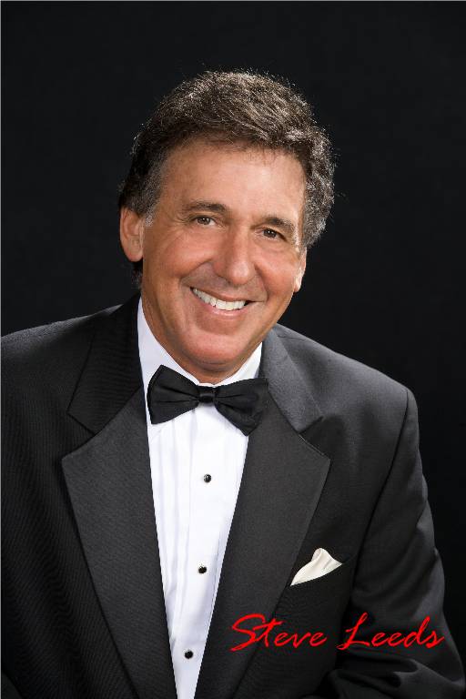 A man in a tuxedo smiling for the camera.